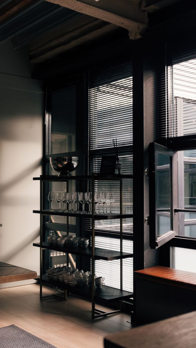 Stylish industrial loft interior in Amsterdam with glass shelving and natural light.