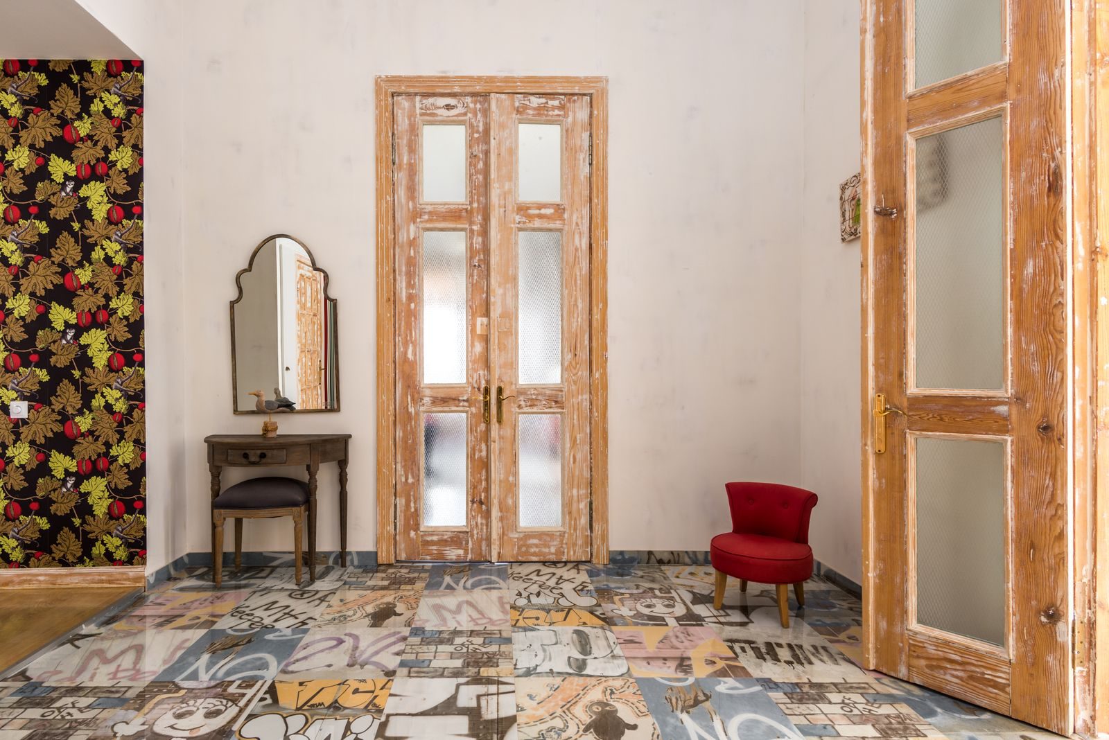 Charming vintage room with distressed wooden doors and graphic patterned floor.